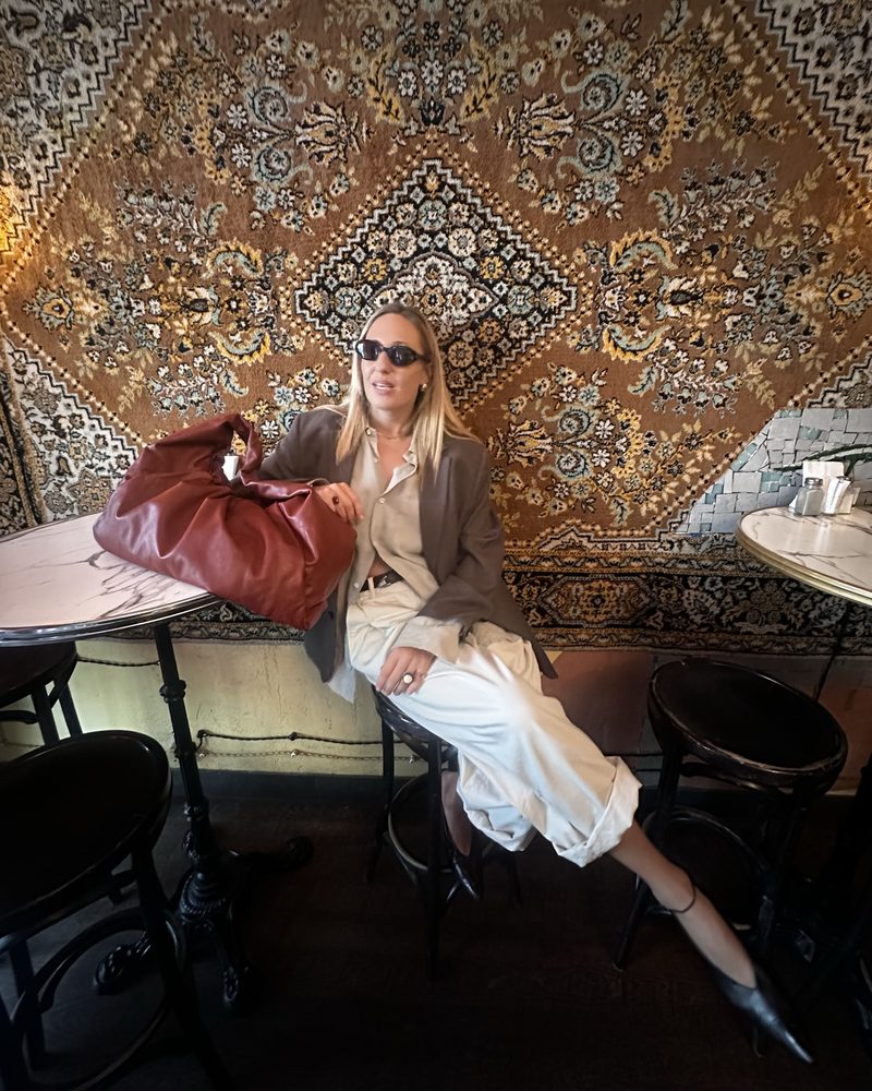 Brown blazer and cream trousers in a carpeted cafe